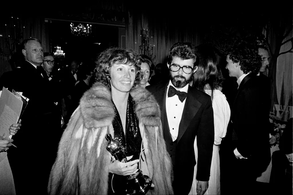 Marcia Lucas carries her Oscar Statuette alongside husband George Lucas at a post Academy Awards party at the Beverly Hills Hotel in Los Angeles, on April 4, 1978.