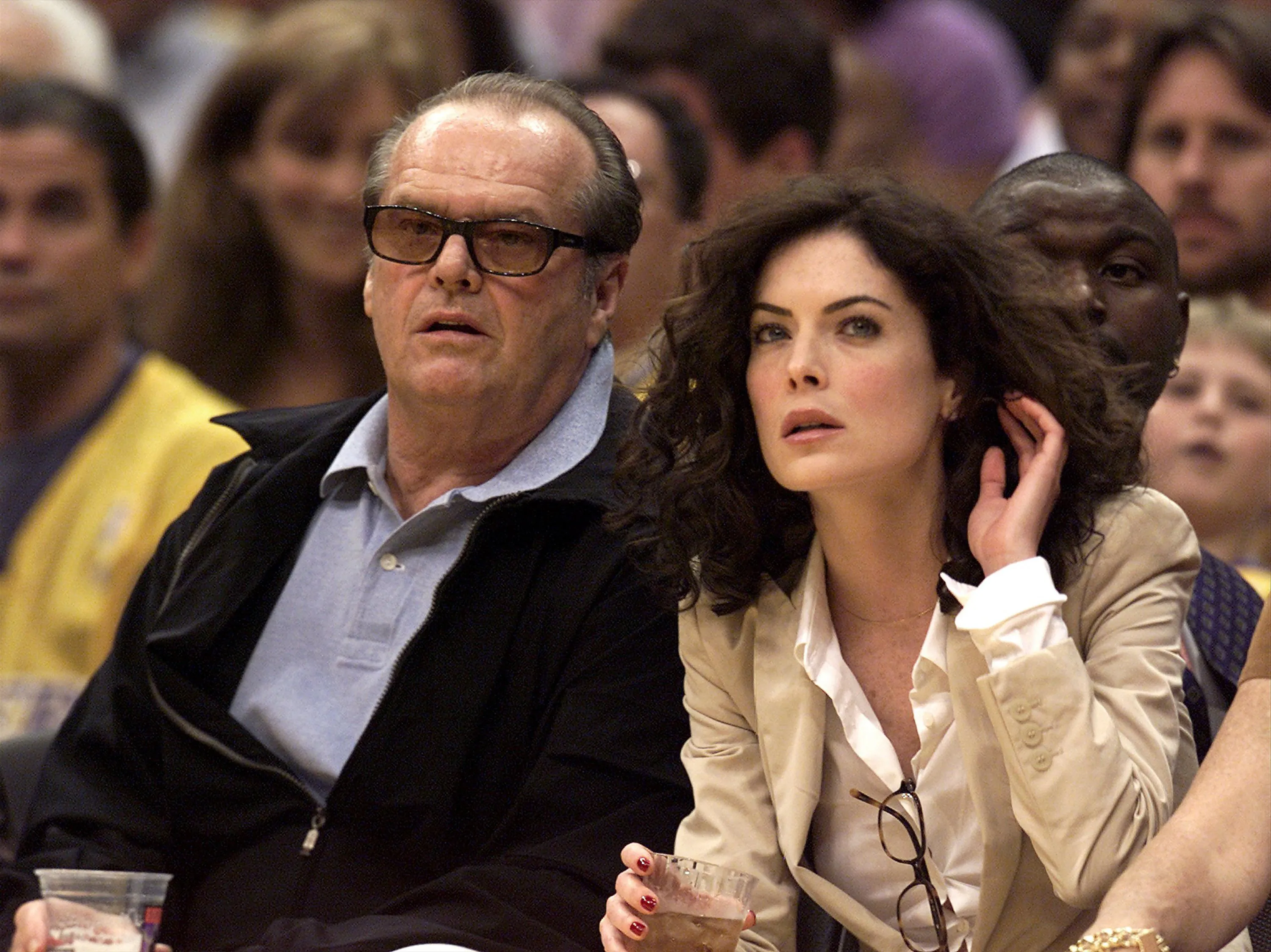 Jack Nicholson and Lara Flynn Boyle watching a basketball game.