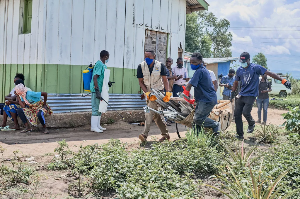Aid workers carrying supplies to set up an Ebola treatment center in Rwampara, Congo.