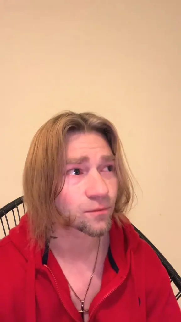 Bear Brown in a red hoodie and a cross necklace.