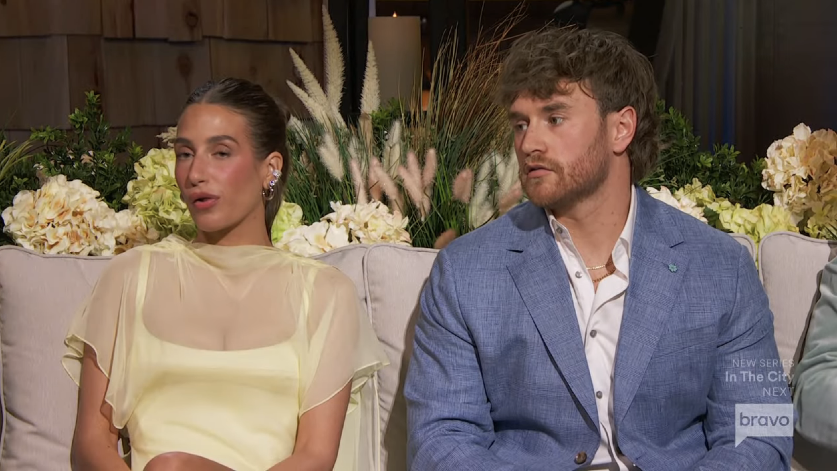 Amanda Batula and West Wilson seated on a couch, appearing on a "Summer House" reunion.