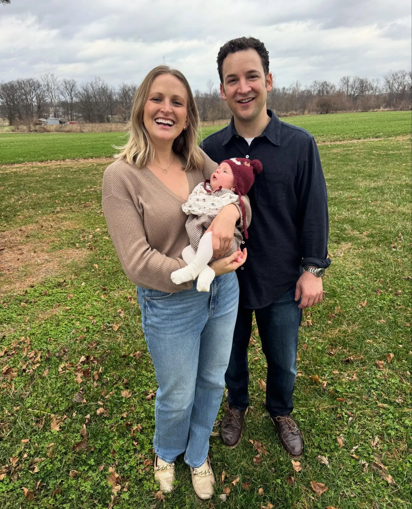 Ben Savage and wife Tessa Angermeier smiling while holding their baby girl.