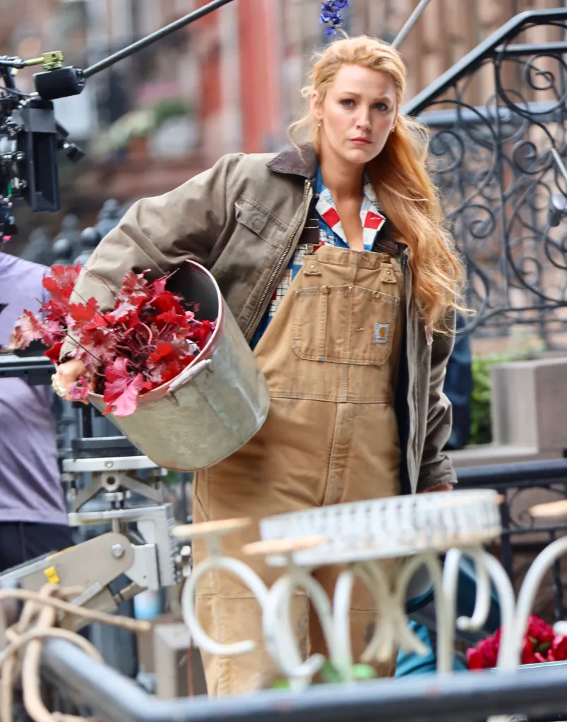 Blake Lively in overalls carrying a bucket of plants on the set of "It Ends With Us."