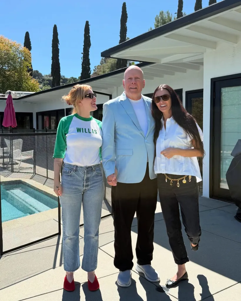 Bruce Willis, Demi Moore, and Rumer Willis stand side-by-side on a patio.