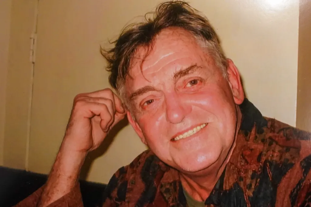 John Grafenecker, an older man with brown hair and a patterned shirt, smiles at the camera.