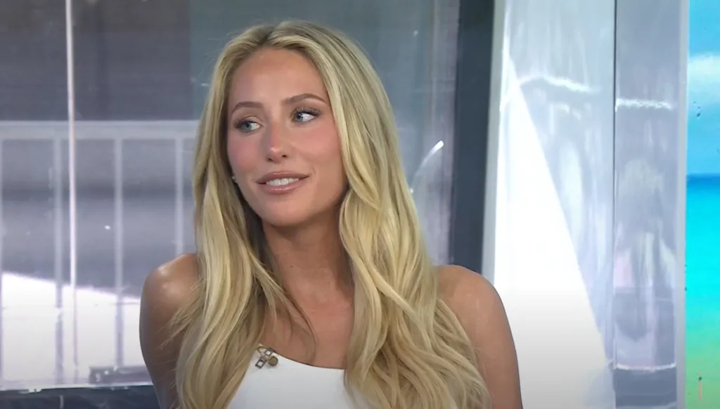 Alix Earle smiling while wearing a white top.