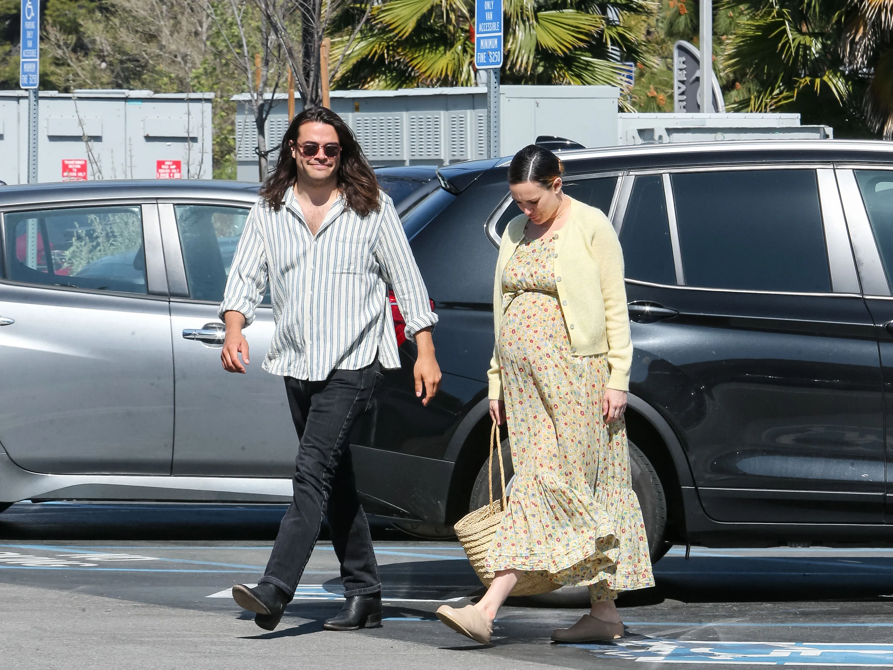 Rumer Willis and Derek Richard Thomas walking in a parking lot.