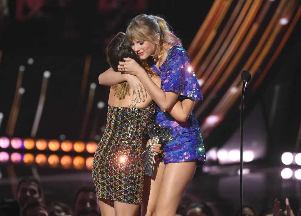 Maren Morris hugging Taylor Swift, who holds the Tour of the Year award.