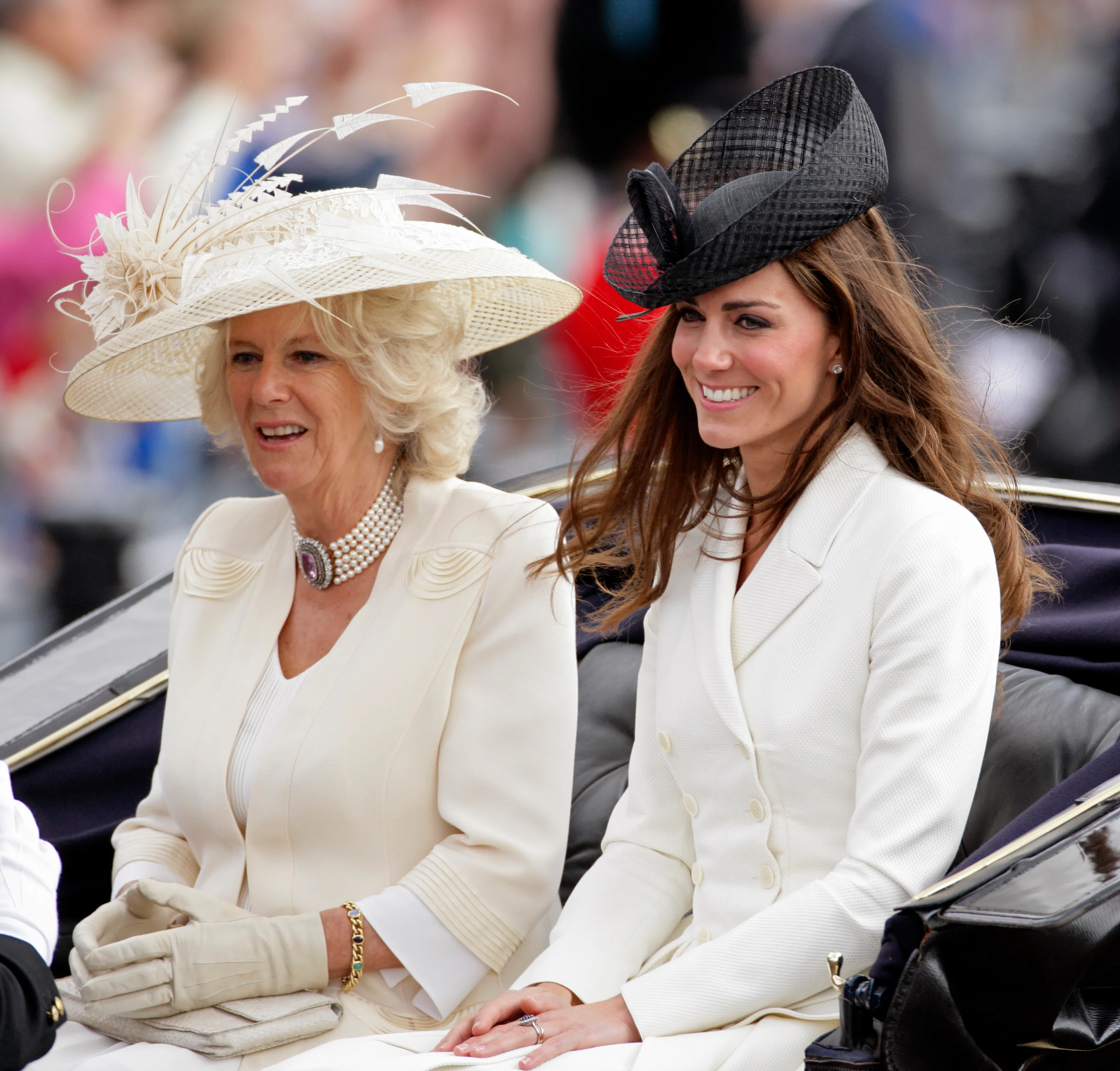 Camilla, Duchess of Cornwall and Catherine, Duchess of Cambridge, riding in a horse-drawn carriage.