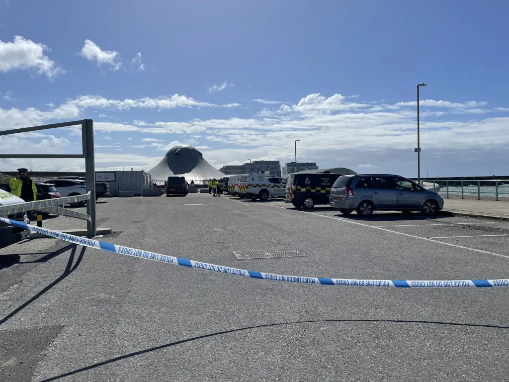 Emergency services on Madeira Drive in Brighton with police tape in the foreground.