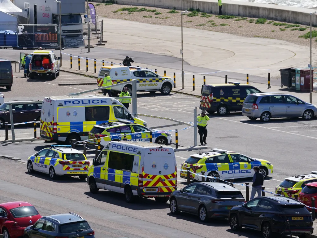 Emergency services vehicles and personnel are at a cordoned-off scene on Madeira Drive, Brighton, after three women's bodies were recovered from the sea.