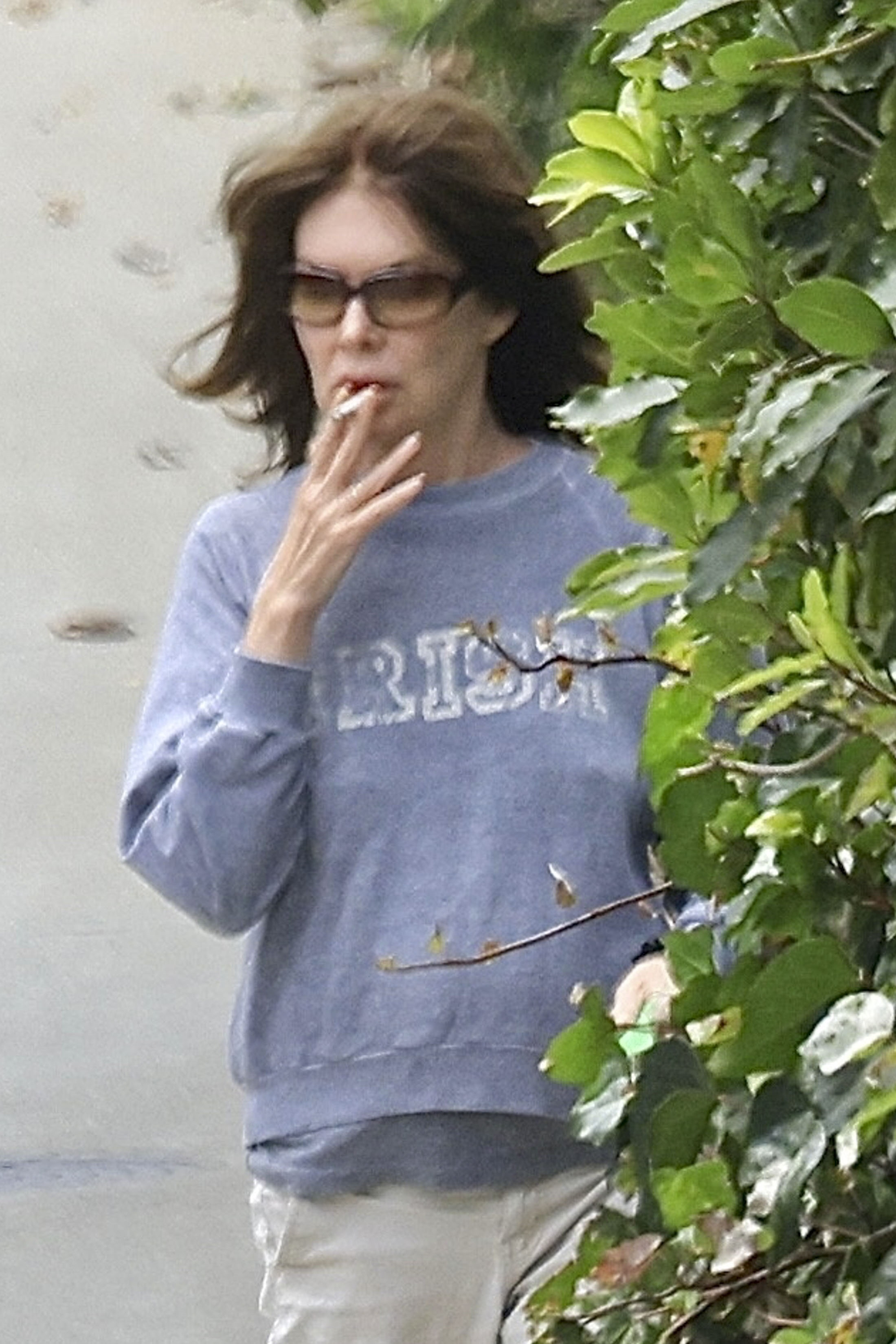 Lara Flynn Boyle smoking a cigarette while walking her dog in Los Angeles.