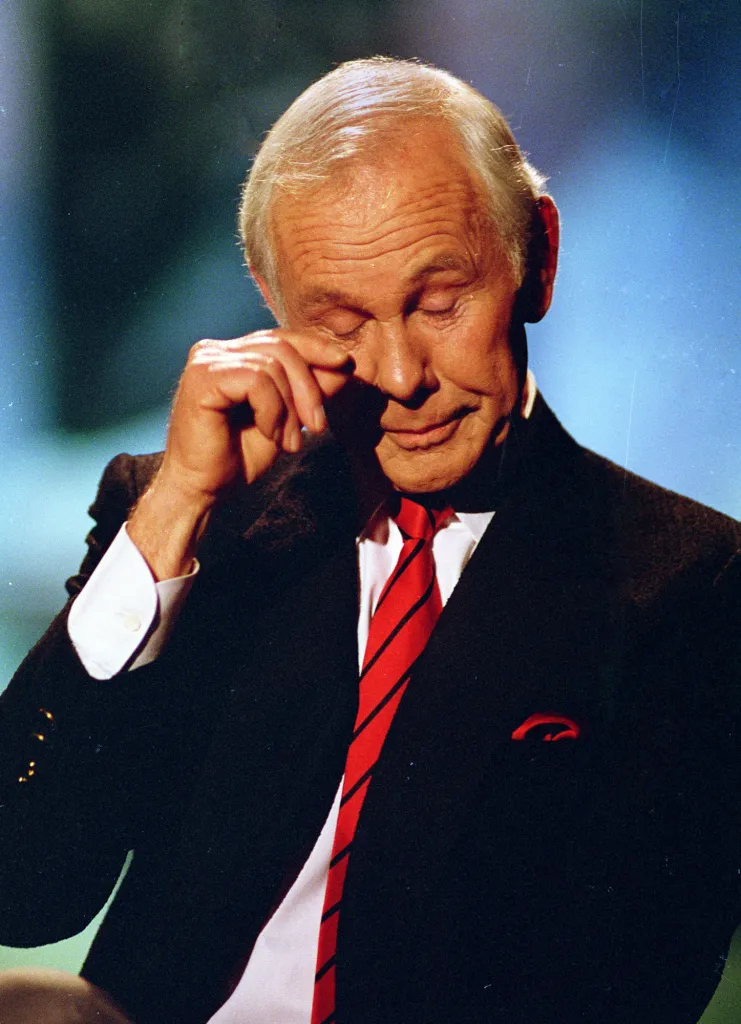 Talk show host Johnny Carson wipes his eye after watching a series of clips from earlier shows during the last taping of "The Tonight Show" in Burbank, Ca., Friday, May 22, 1992.