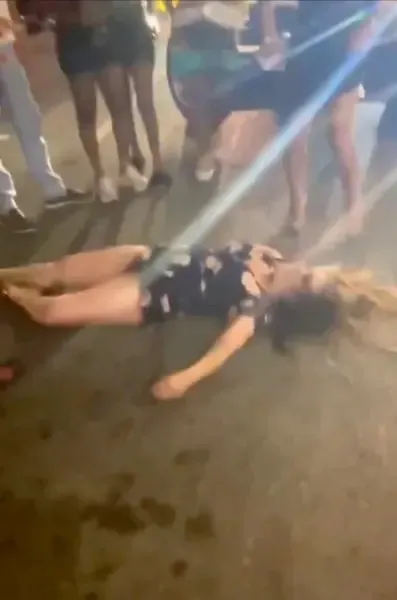A woman lies unconscious in the street after being knocked out during a brawl in Cincinnati on July 26, 2025.