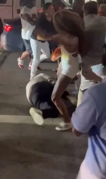 People kick a man lying on the ground during an early morning street brawl in Cincinnati, Ohio.