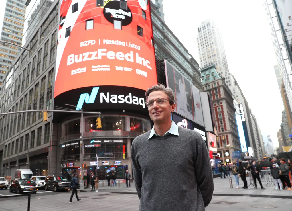 Jonah Peretti, CEO of BuzzFeed, standing in Times Square in front of a large screen displaying "BuzzFeed Inc." and the Nasdaq logo.