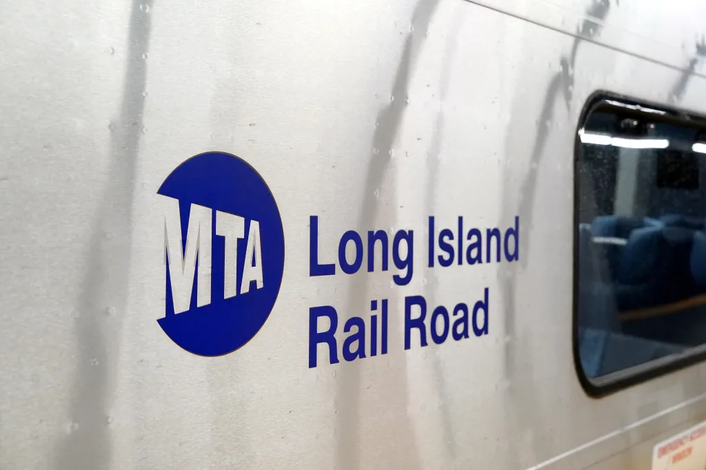 Side of a Long Island Railroad train with an MTA logo and "Long Island Rail Road" in blue text.