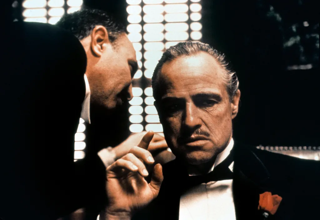 Salvatore Corsitto whispering to Marlon Brando in The Godfather.