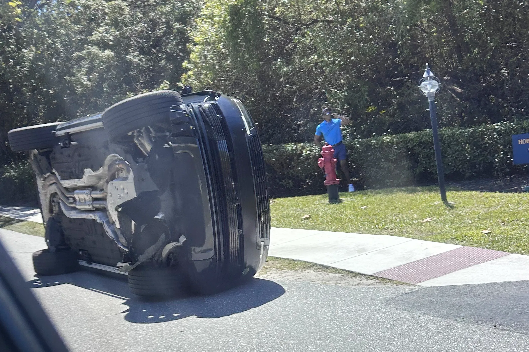 Tiger Woods standing near his overturned SUV after a rollover car crash.