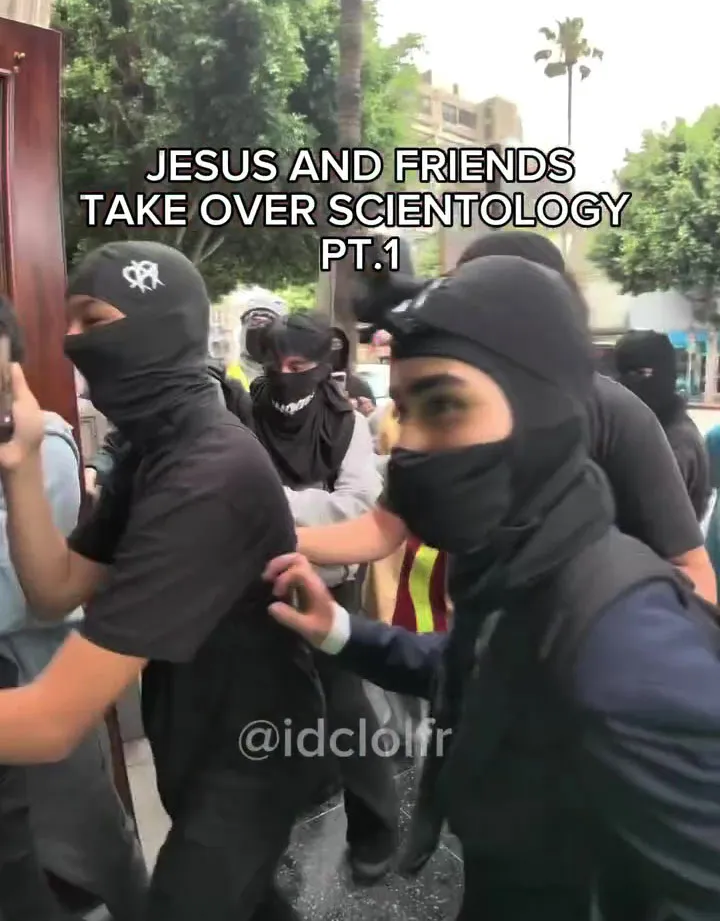 Group of people in black balaclavas attempting to break into a Scientology building in San Diego.