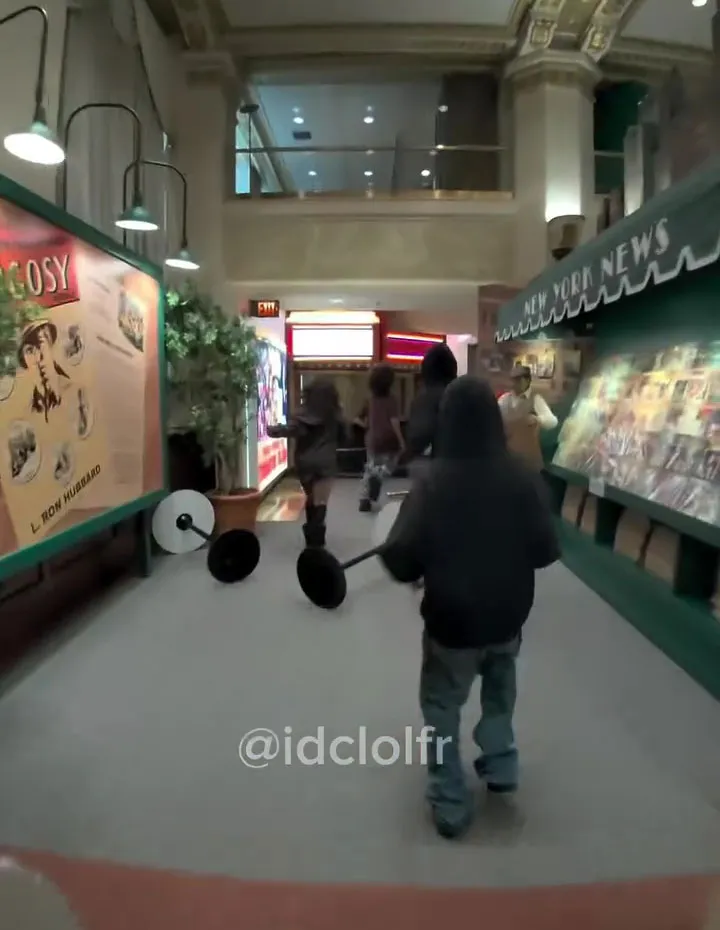 People carrying barbells walking down a hallway in a Scientology building.