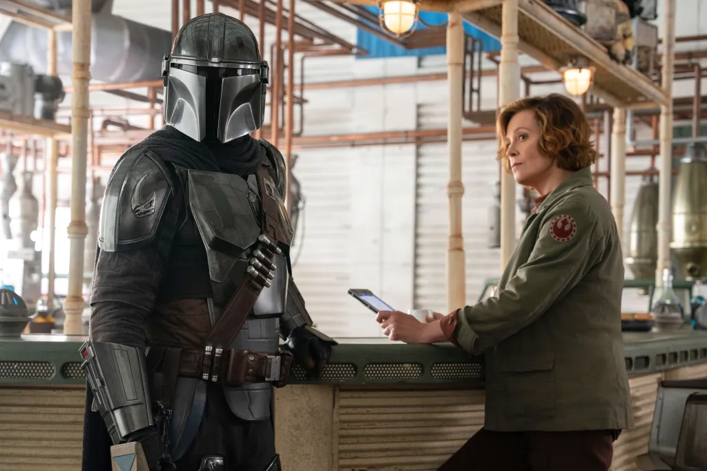 The Mandalorian, played by Pedro Pascal, and Colonel Ward, played by Sigourney Weaver, in a scene from "Star Wars: The Mandalorian and Grogu."