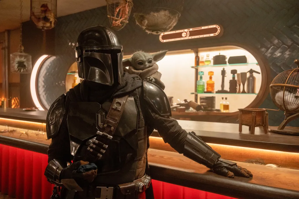 The Mandalorian with Grogu perched on his shoulder.