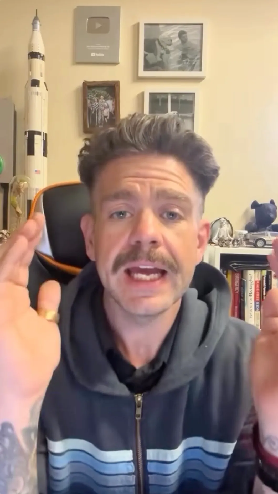 Jack Osbourne, with a mustache and short hair, wearing a striped hoodie and a gold ring, speaks to the camera.