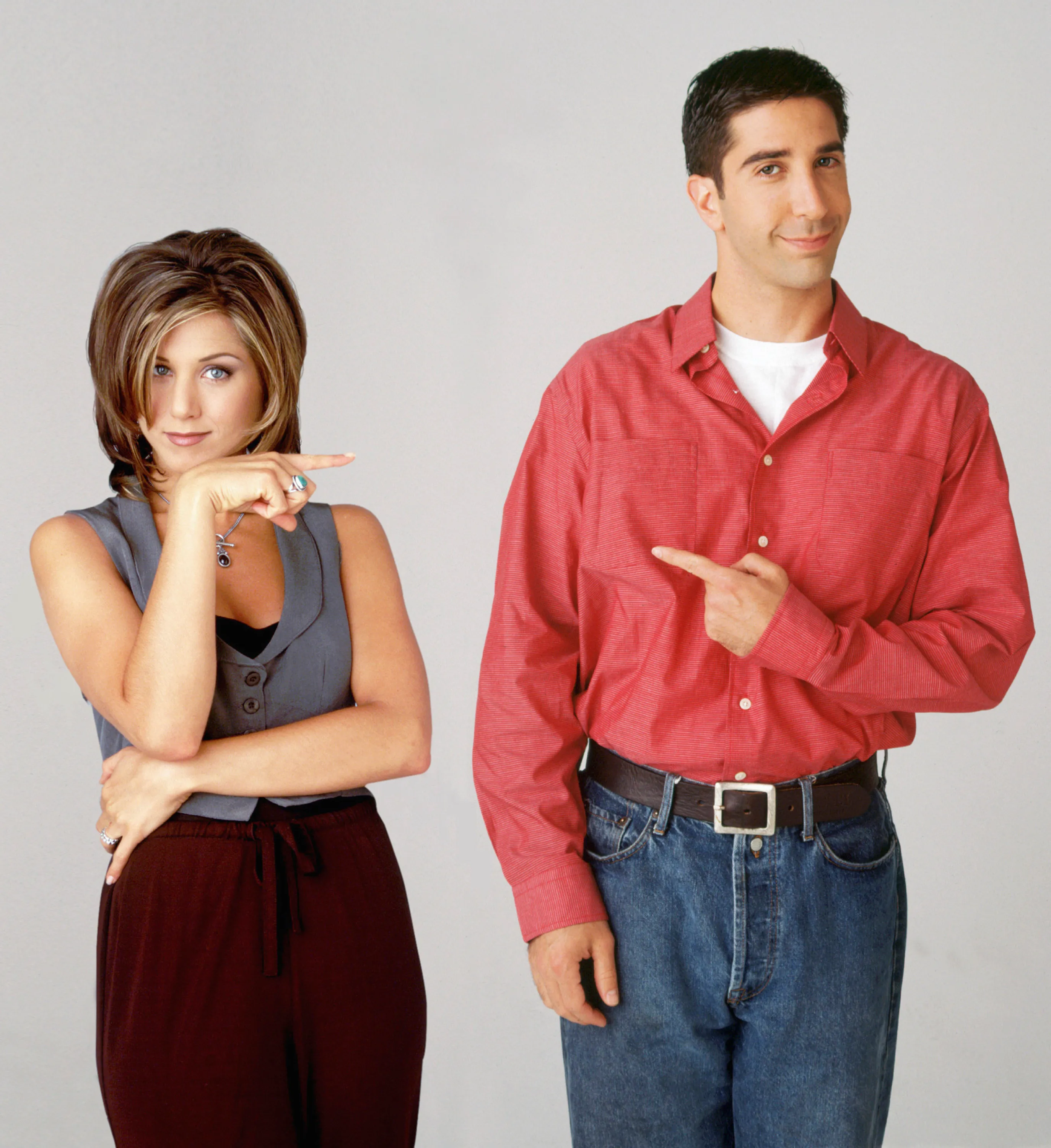 Jennifer Aniston as Rachel Green and David Schwimmer as Ross Geller, from the TV show "Friends," standing and pointing at each other.