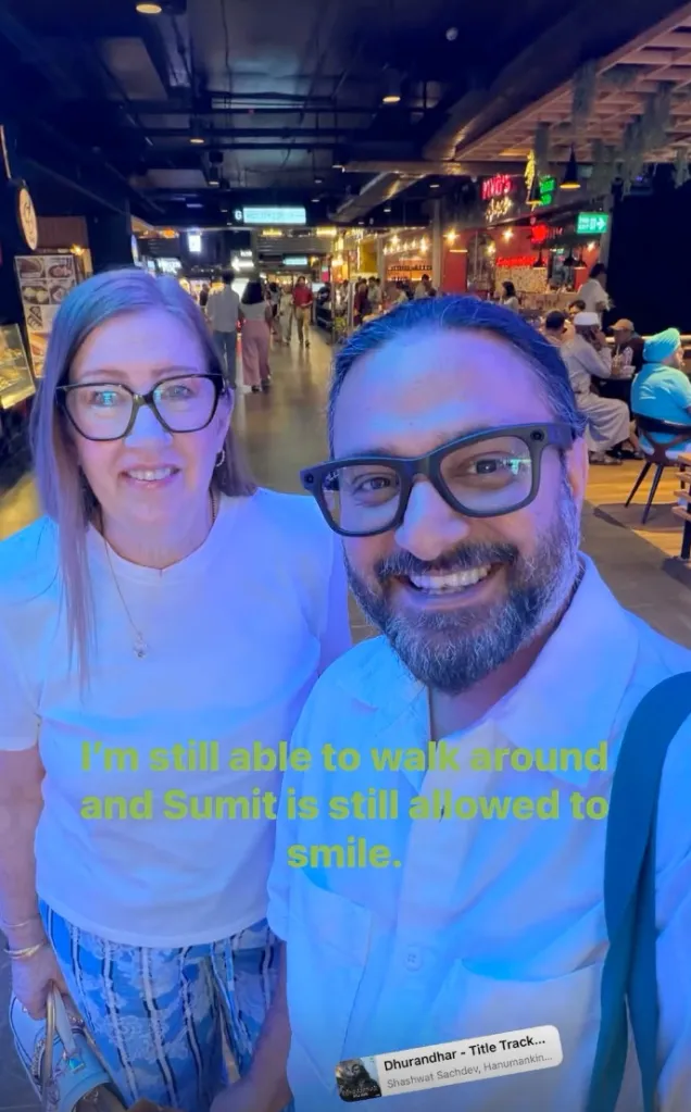 Jenny Slatten and Sumit Singh smiling for a selfie in a brightly lit indoor space.