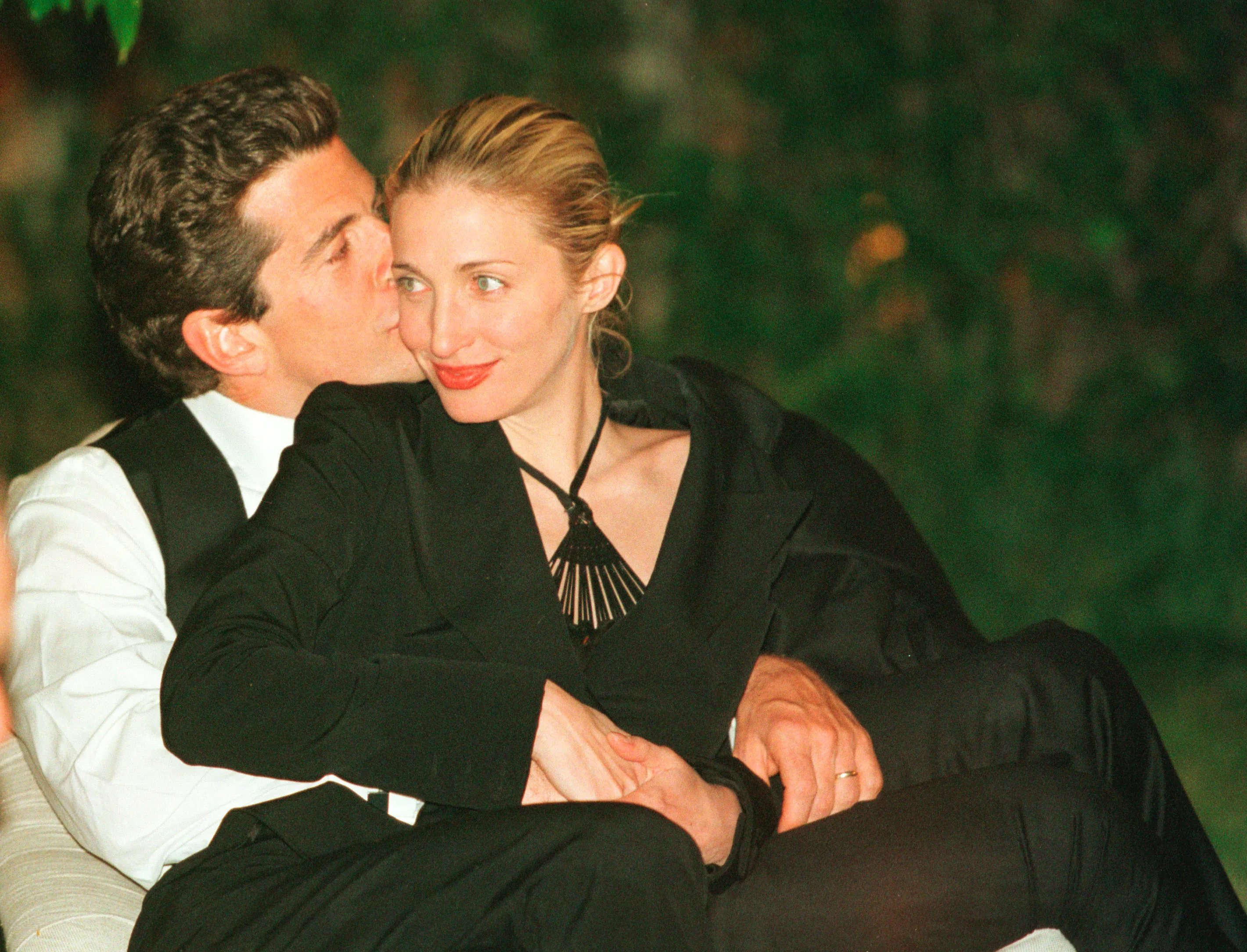 John F. Kennedy Jr. kissing Carolyn Bessette-Kennedy on the cheek.