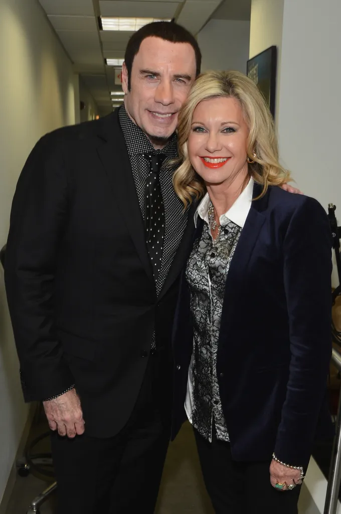 John Travolta and Olivia Newton-John smiling at a SiriusXM event.