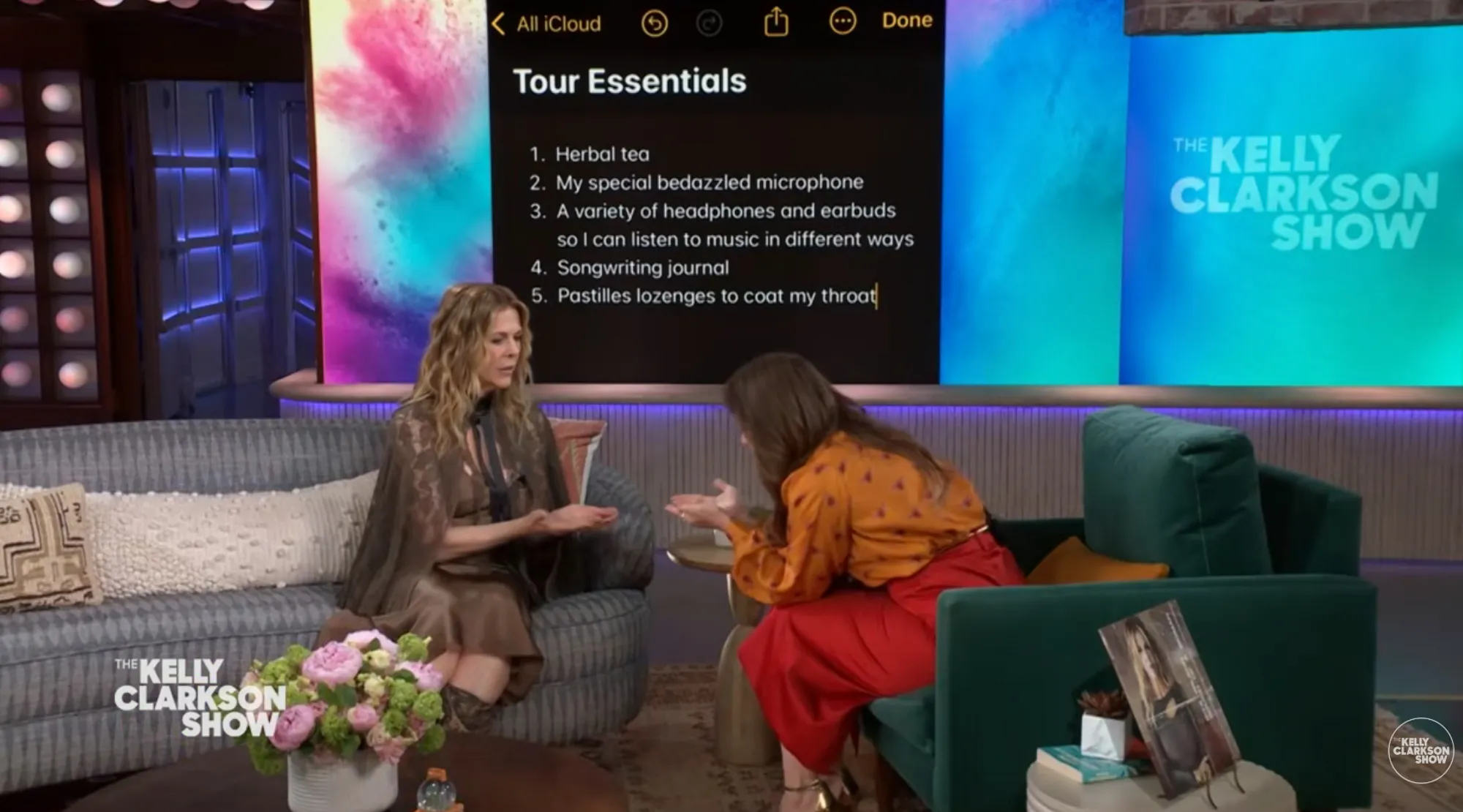 Kelly Clarkson discusses "Tour Essentials" from a list on a screen during an interview on "The Kelly Clarkson Show."