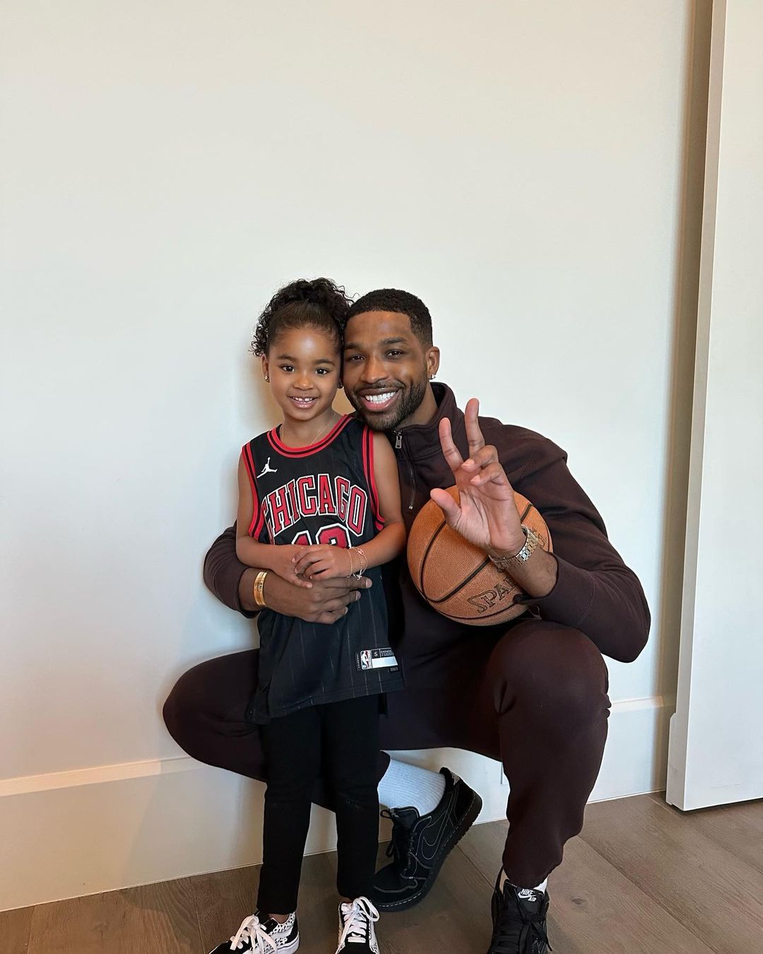Tristan Thompson and True posing for a photo, with True in a Chicago Bulls jersey and Thompson holding a basketball.