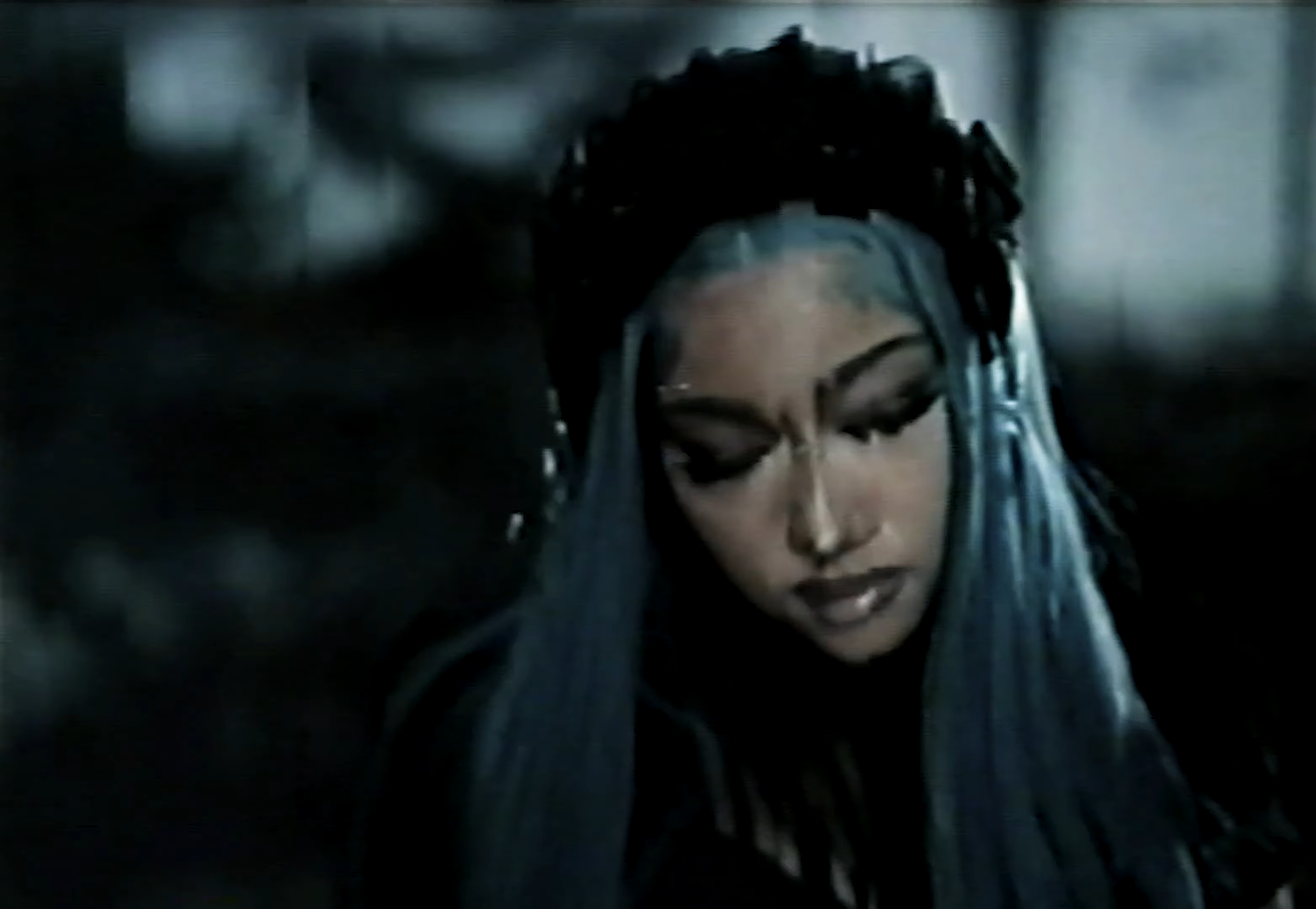 North West wearing heavy makeup and blue hair.