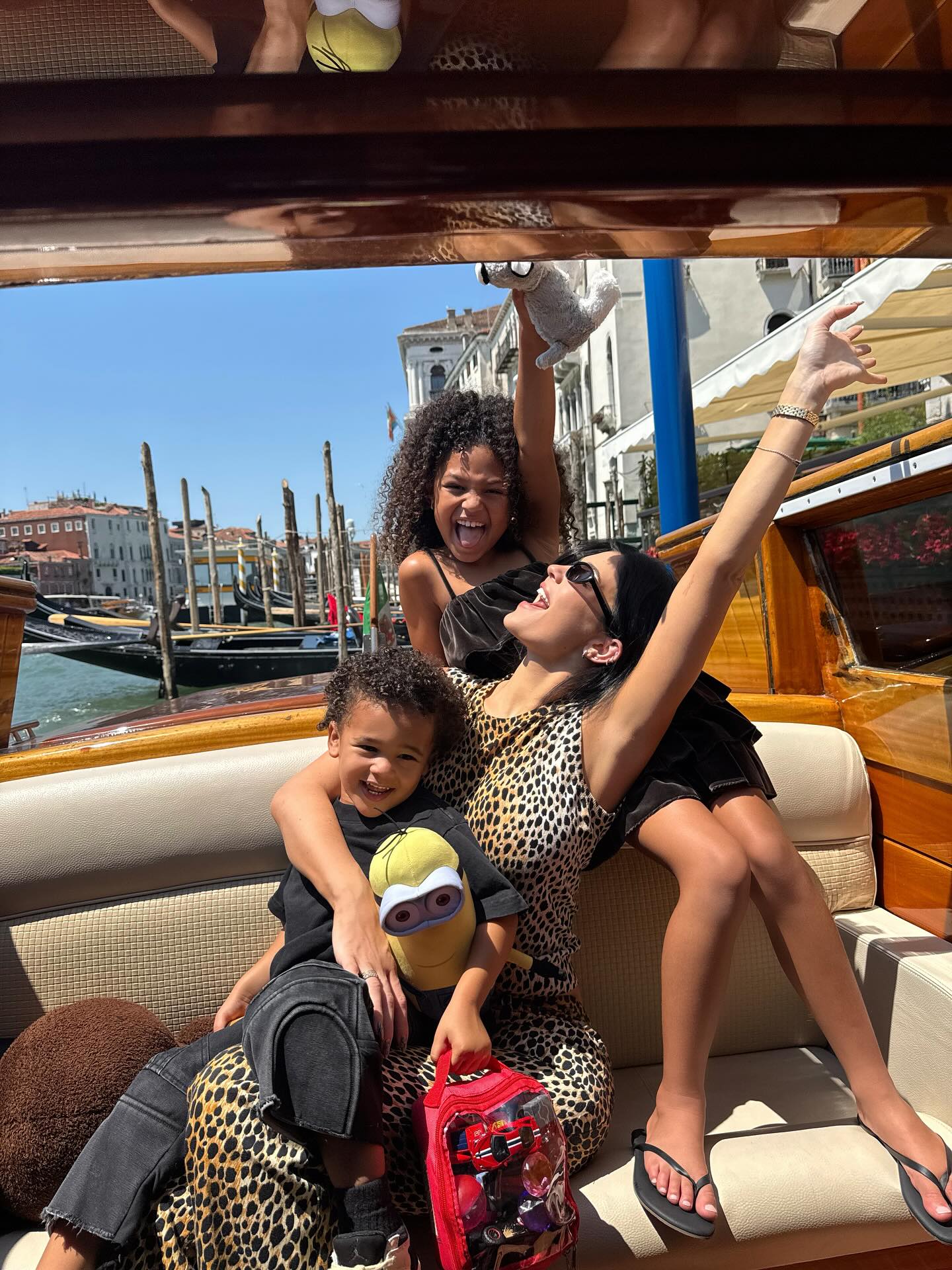 Kylie Jenner, Stormi, and Aire Webster in a boat on a canal.