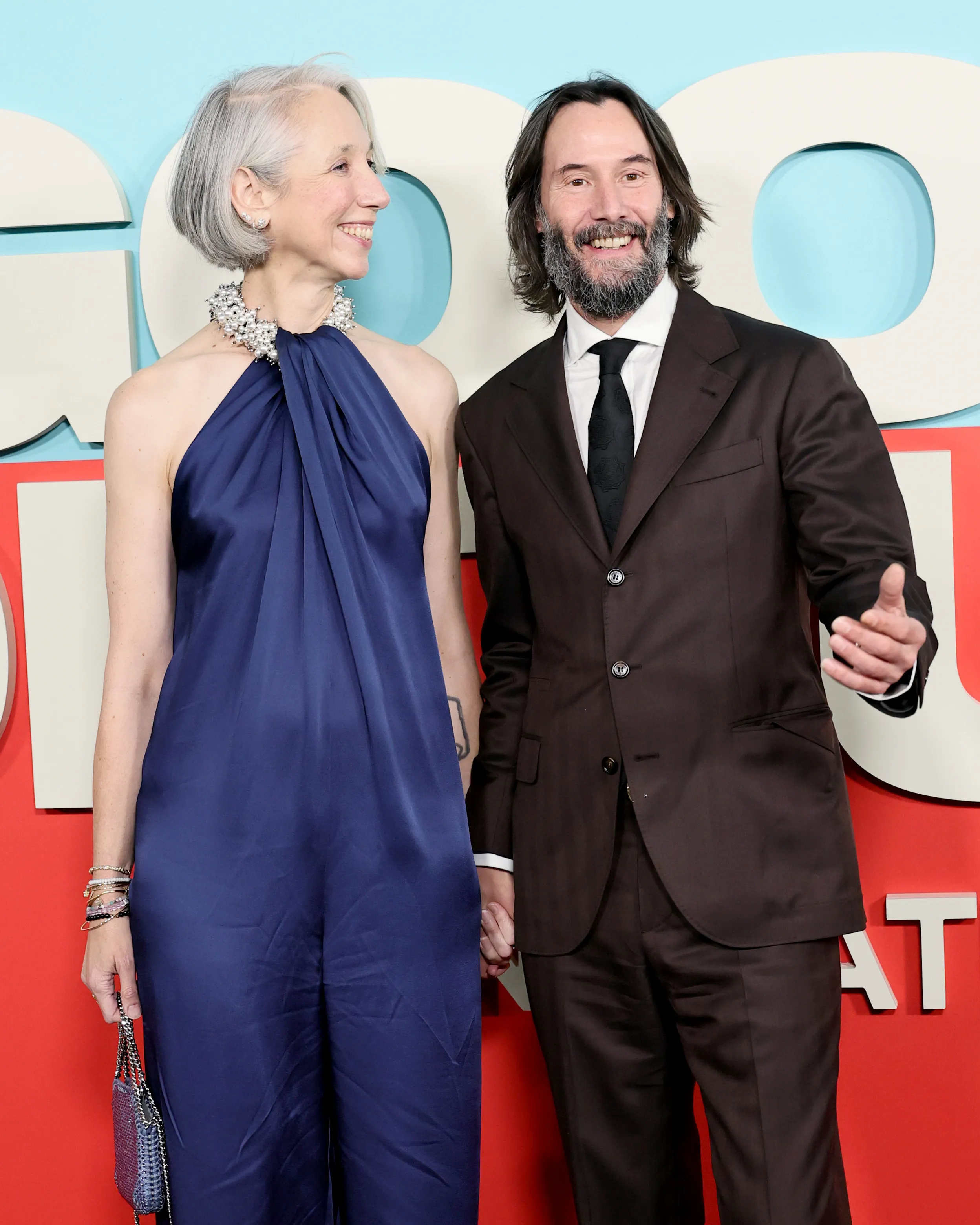 Alexandra Grant in a blue jumpsuit and Keanu Reeves in a brown suit attend the "Good Fortune" New York Screening.