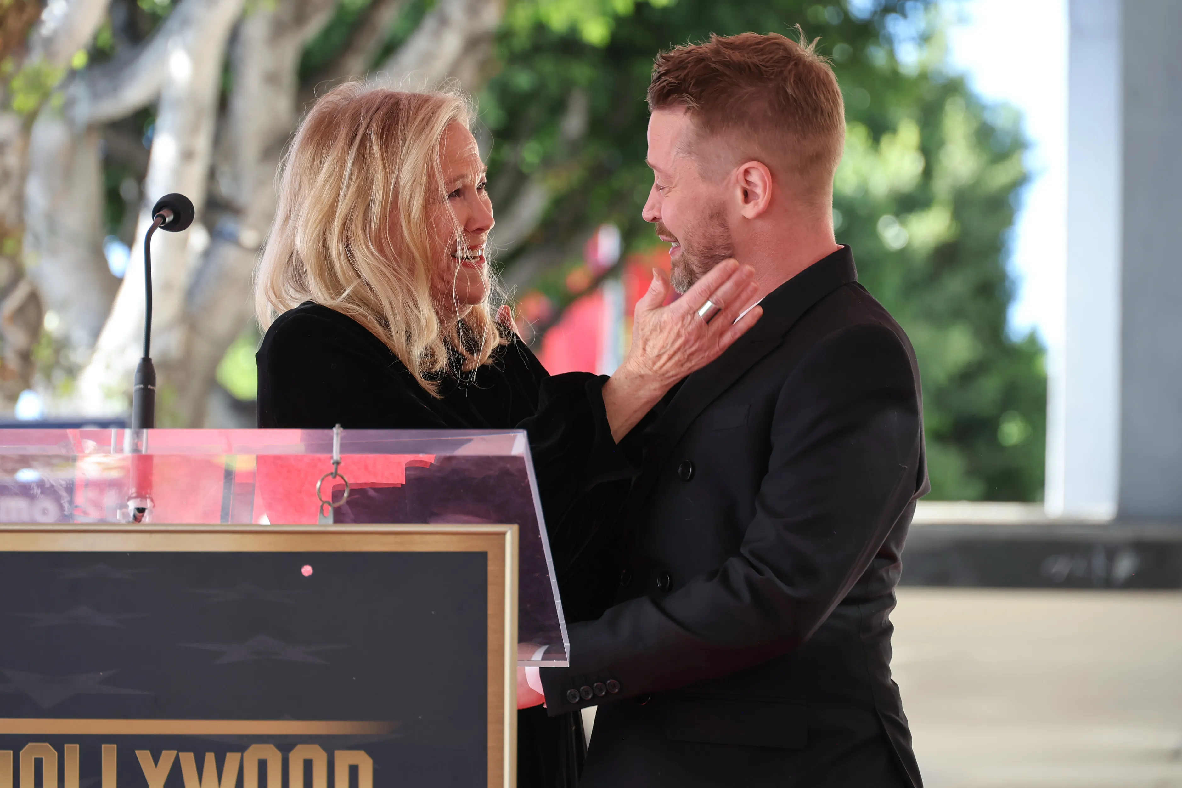 Catherine O'Hara places her hand on Macaulay Culkin's face during his Hollywood Walk of Fame ceremony.