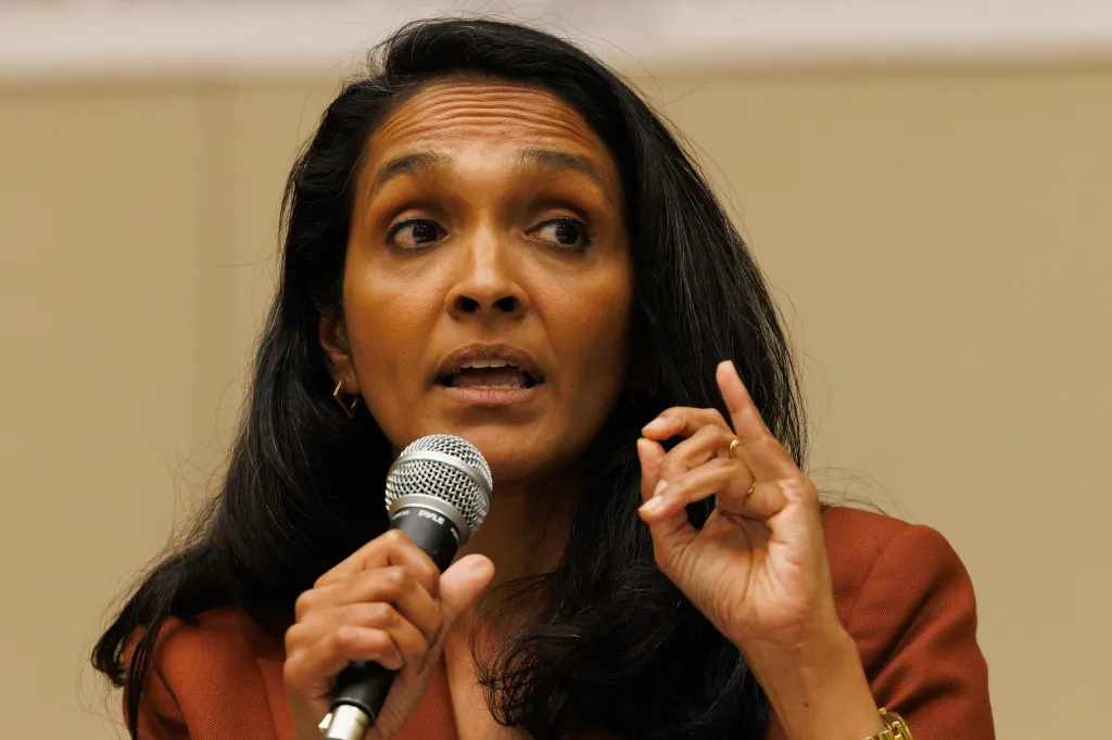 Los Angeles City Council member Nithya Raman speaking at a debate with a microphone in hand.