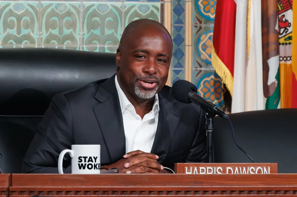 Los Angeles City Council President Marqueece Harris-Dawson at a council meeting with a "Stay Woke" coffee mug.