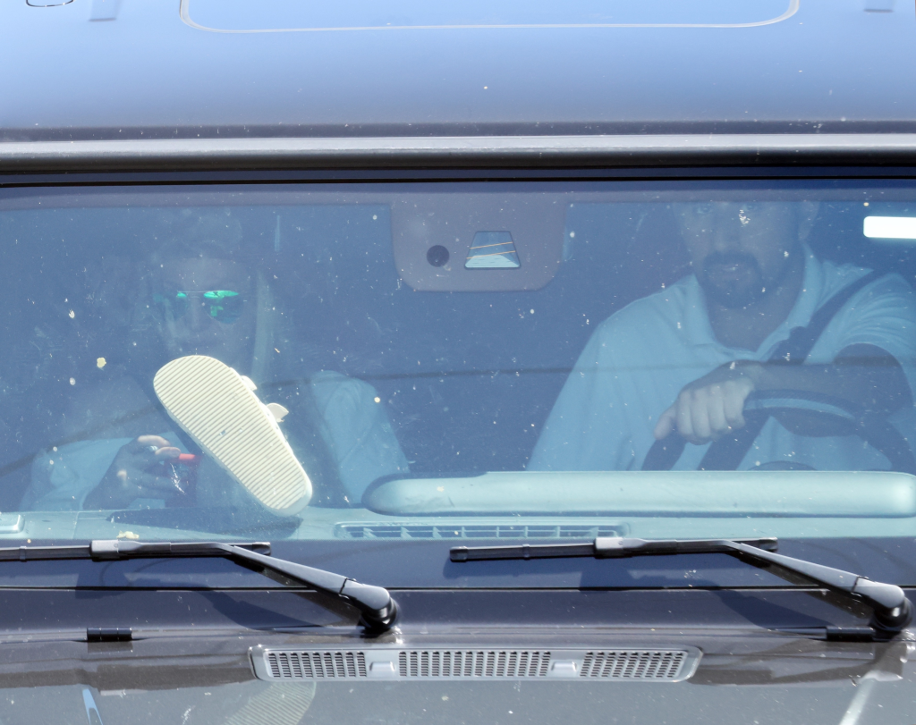 Britney Spears smoking and resting her foot on the dashboard as she is driven in a Mercedes G-Wagon.