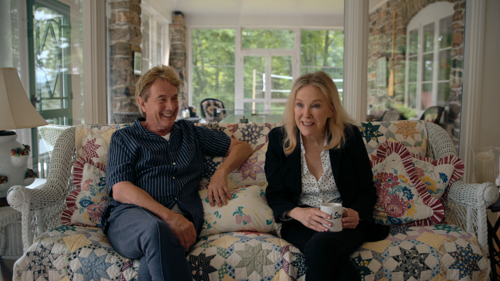 Martin Short and Catherine O'Hara sitting on a quilt-covered couch from 
