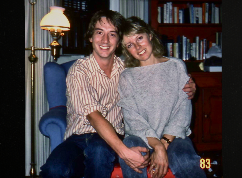 Martin Short and Nancy Dolman smiling in a living room.