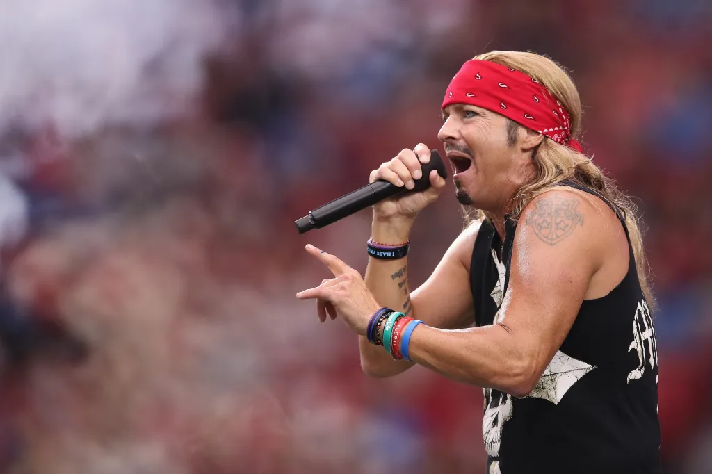 Musician Bret Michaels performing during a half-time show at an NFL game.