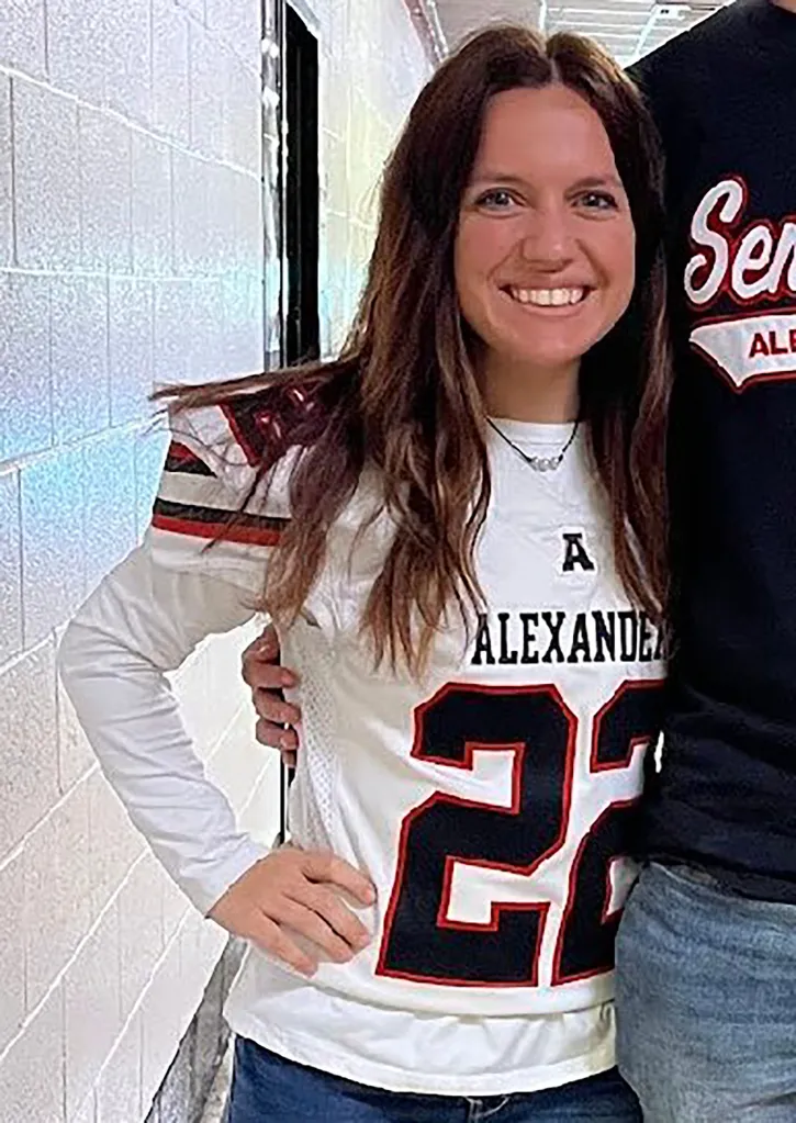 Maris Nichols, a former Alexander High School teacher, wearing a white sports jersey with "Alexander" and number "22" printed on it.