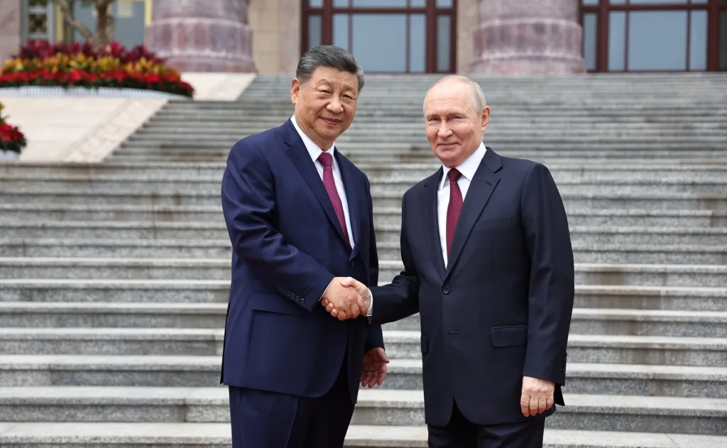 Chinese President Xi Jinping and Russian President Vladimir Putin shake hands in Beijing.