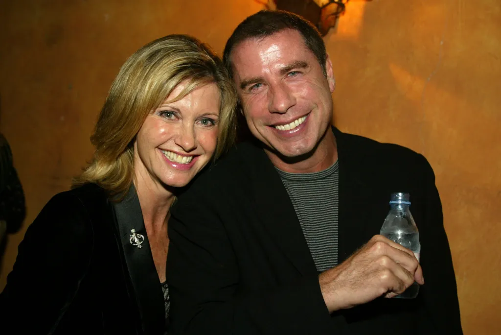 Olivia Newton-John and John Travolta smiling at the One World, One Child Benefit Concert.