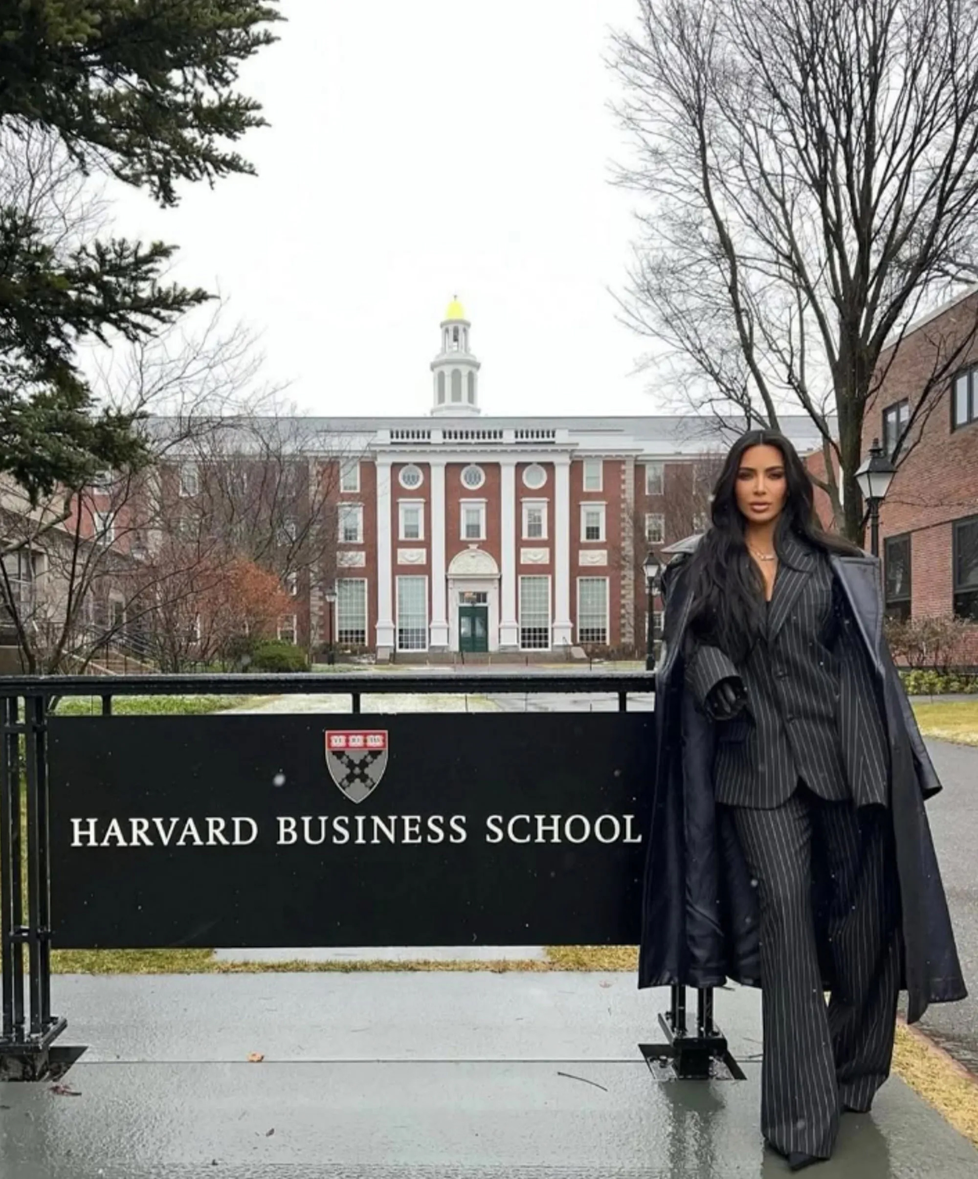 Kim Kardashian standing in front of a "Harvard Business School" sign.