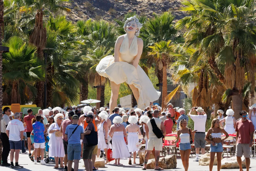 People dressed as Marilyn Monroe gather around the "Forever Marilyn" statue in Palm Springs, California.