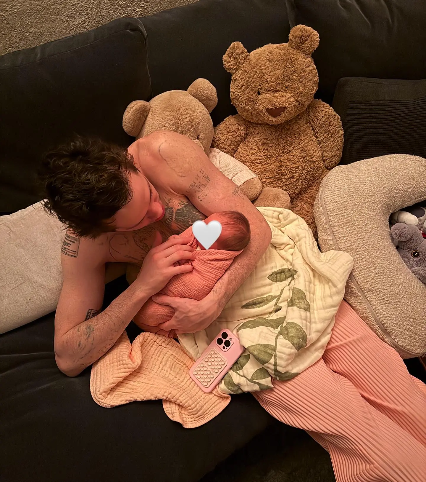 Pete Davidson with a baby wrapped in a pink blanket.